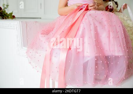Lace skirt decoration, beadwork, close-up, selective focus. Beads thread clothing detail macro, pastel color. kids dress fashion for party, event Stock Photo