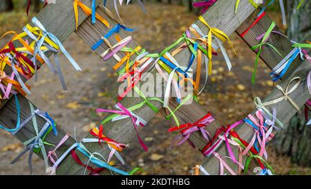Many colorful ribbons on the fence with selective focus and blurred background. Stock Photo