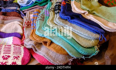 Warm winter woolen knitted socks in different sizes and colors. Waiting for winter. Handmade. Stock Photo
