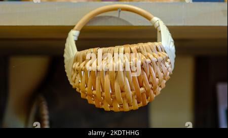 A small decorative wicker basket hung on a nail. handmade. Stock Photo