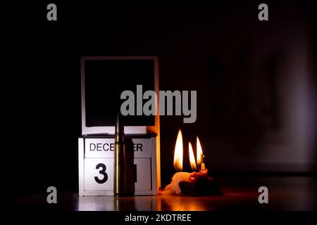 December 31 is written on wooden cubes and a combat bullet on a table in the dark, candles, Happy New Year, calendar and time of war in Ukraine Stock Photo