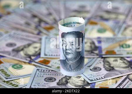 Chinese yuan banknote rolled up on US dollars background. Concept of trade war between the China and USA, economic, sanctions, tourism and investment Stock Photo