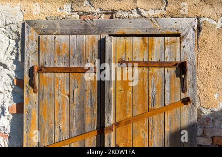 Old wooden door with rusty hinge Stock Photo