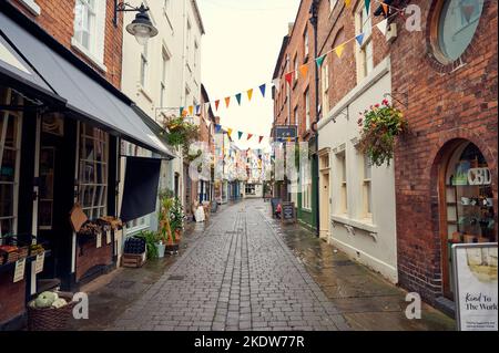 07 Nov 2022 - Hereford  UK: Church Street. Old narrow street of shops in three storey  three story buildings on cloudy day with no people Stock Photo