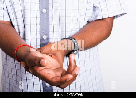 black man holds his wrist hand injury, feeling pain Stock Photo