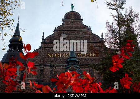 Stockholm, Sweden - November 4, 2022: Nordiska museet (Nordic Museum) facade behind red Autumn foliage in Stockholm, Sweden. Stock Photo