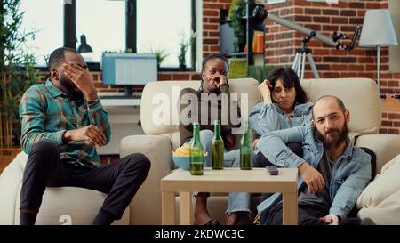 Diverse people getting scared watching horror movie on television ...