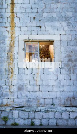 Broken window on abandoned brick building Stock Photo