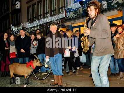 STRASBOURG, FRANCE - DECEMBER 20, 2015: Street musicians and the public (including a man with goat) at Christmas market in Strasbourg. Stock Photo