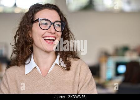 Young relaxed happy smiling pretty professional business woman at workplace. Stock Photo