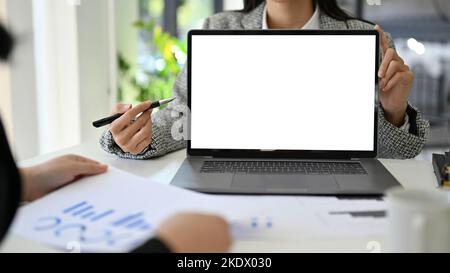 Professional Asian businesswoman or female financial analyst or consultant explaining her financial investment plan and showing or presenting somethin Stock Photo