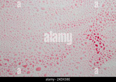 red colored water drops on gray background, abstract texture, soft focus close up. Stock Photo