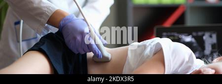 Doctor conducting ultrasound examination of kidneys to child in clinic Stock Photo