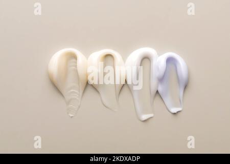 Face cream samples on beige background. Cream strokes of different texture and colors. Skin care cosmetics Stock Photo