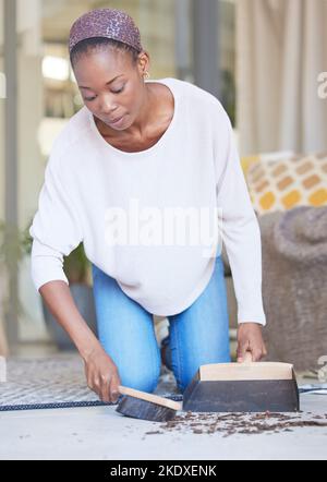 Dust, woman and cleaning on a floor, sweeping and scoop in a living room for hygiene, wellness and healthy home space. Dirt, black woman and carpet Stock Photo