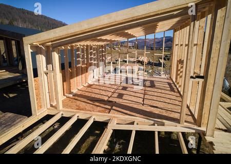 Aerial view of wooden frame house on pile foundation in the Scandinavian style barnhouse under construction in the mountains. Stock Photo