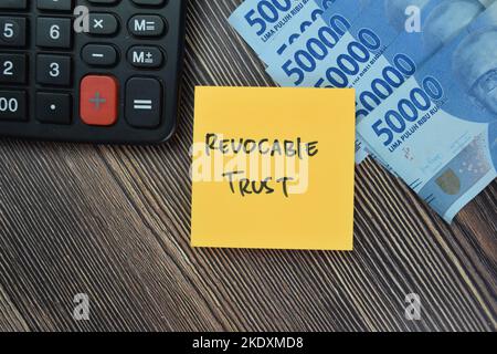 Concept of Revocable Trust write on sticky notes isolated on Wooden Table. Stock Photo