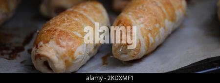 Homemade sausages in dough on baking sheet Stock Photo