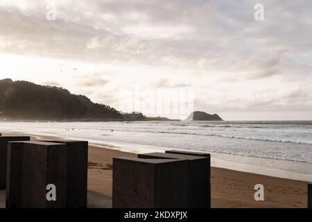 Sea waves rolling on sandy beach against cloudy sundown sky in evening on resort Stock Photo
