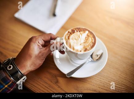 Brewed to perfection. an unidentifiable man having a cup of coffee in a coffee shop. Stock Photo