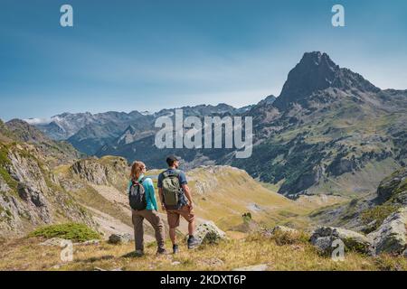 Young Attractive Couple looking the panoramic views of the amazing mountains landscape in summer.  Stock Photo