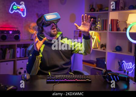 Gamer at his room playing VR headset exploring digital world, touching virtual reality subjects. Stock Photo