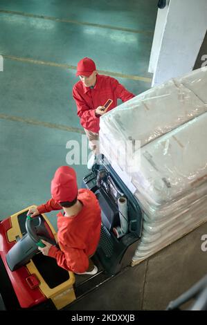 Two experienced warehouse workers discussing freight transportation Stock Photo