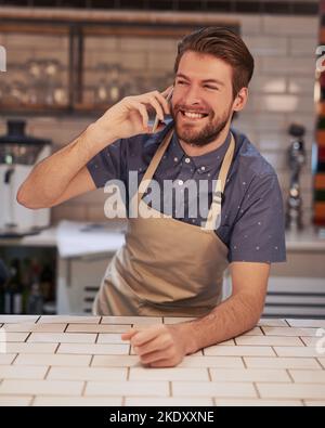 Yes, this is the most famous coffee drinking place. a handsome young man working in a cafe. Stock Photo