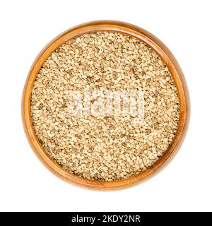 Unhulled sesame seeds, benne in a wooden bowl. Seeds of Sesamum indicum, with rich and nutty flavor. Common ingredient in cuisines around the world. Stock Photo
