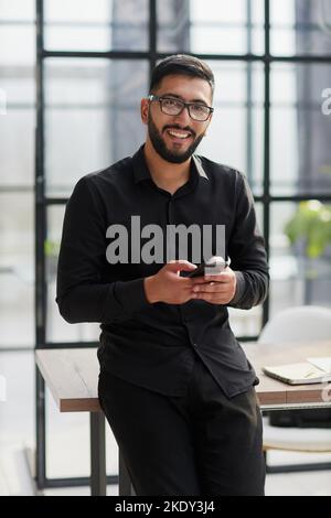 Young casual Businessman holding and using smartphone for sms messages Stock Photo