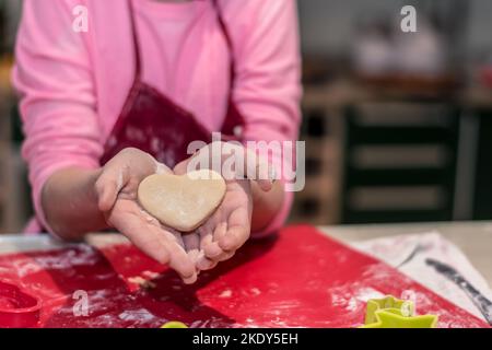 raw gingerbread pastry in heart shape in human hands Stock Photo