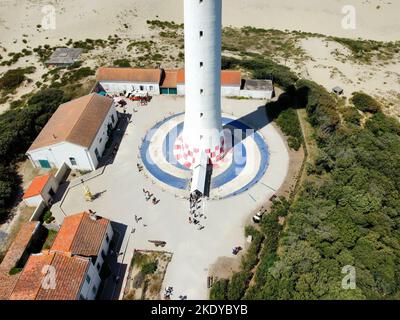 A drone shot  of the bottom of the Lighthouse of La Coubre in La Tremblade, France on green meadows Stock Photo