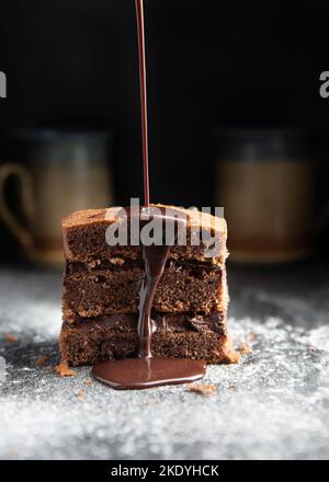 A piece of layered chocolate cake with pouring chocolate. Stock Photo