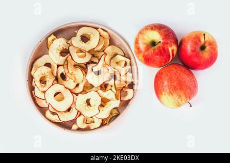 Bowl of homemade dried organic apple sliced chips . Healthy snacks isolated on white background. Top view Stock Photo