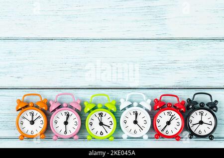 Many different alarm clocks on blue wooden background with copy space for your text or message. Stock Photo