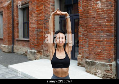 Attractive adult woman warming up stretching her arms Stock Photo