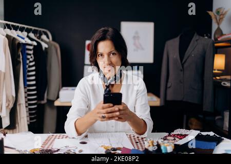 Female designer using smartphone Stock Photo