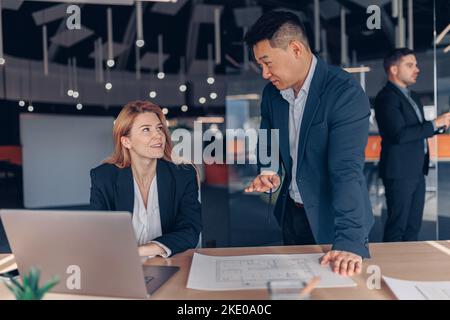 Two multiethnic colleagues working together on project in modern office Stock Photo