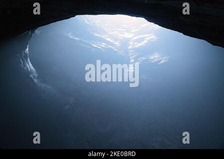 Rock cave with hole through which light shines. Underworlds in Sweden. Mystical atmosphere. Nature shot from Scandinavia Stock Photo