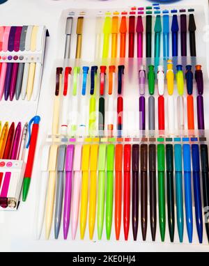 a group multi-colored plastic ballpoint pens on white table Stock Photo