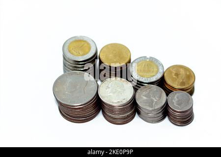 Egyptian and American coins in stacks of 1 EGP LE one pound, fifty piasters, half a dollar 50 cents, 25 cents quarters, dime 10 cents and five cents, Stock Photo