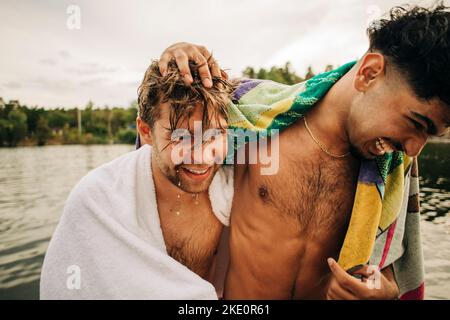 Happy male friends wearing towel enjoying during vacation Stock Photo