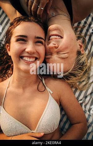 Directly above view of happy female friends lying down together during vacation Stock Photo