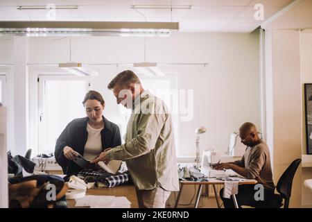 Design professionals discussing together while working in workshop Stock Photo