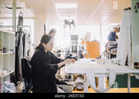 Side view of female fashion designer working at workshop Stock Photo