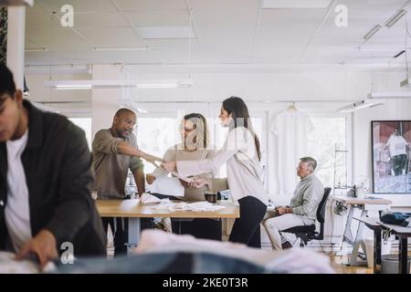 Male and female design professionals discussing together at workshop Stock Photo