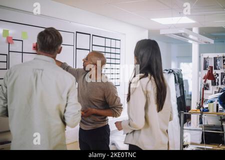 Male and female colleagues discussing during meeting at workshop Stock Photo