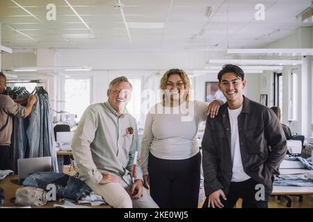 Young female fashion designer with male colleagues at workshop Stock Photo