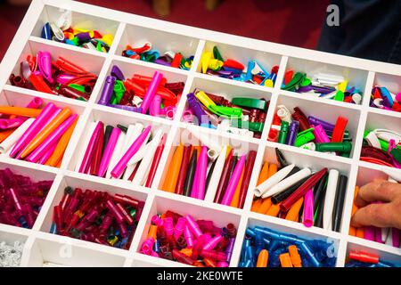 multi-colored plastic disassembled ballpoint pens in boxes, close up Stock Photo