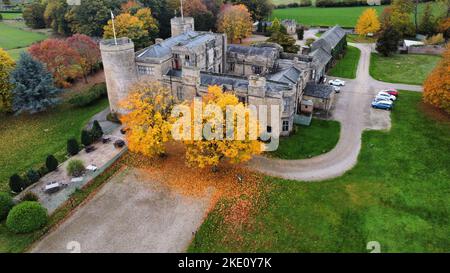 An aerial view of Walworth Castle with colorful autumn trees and parked vehicles in England Stock Photo